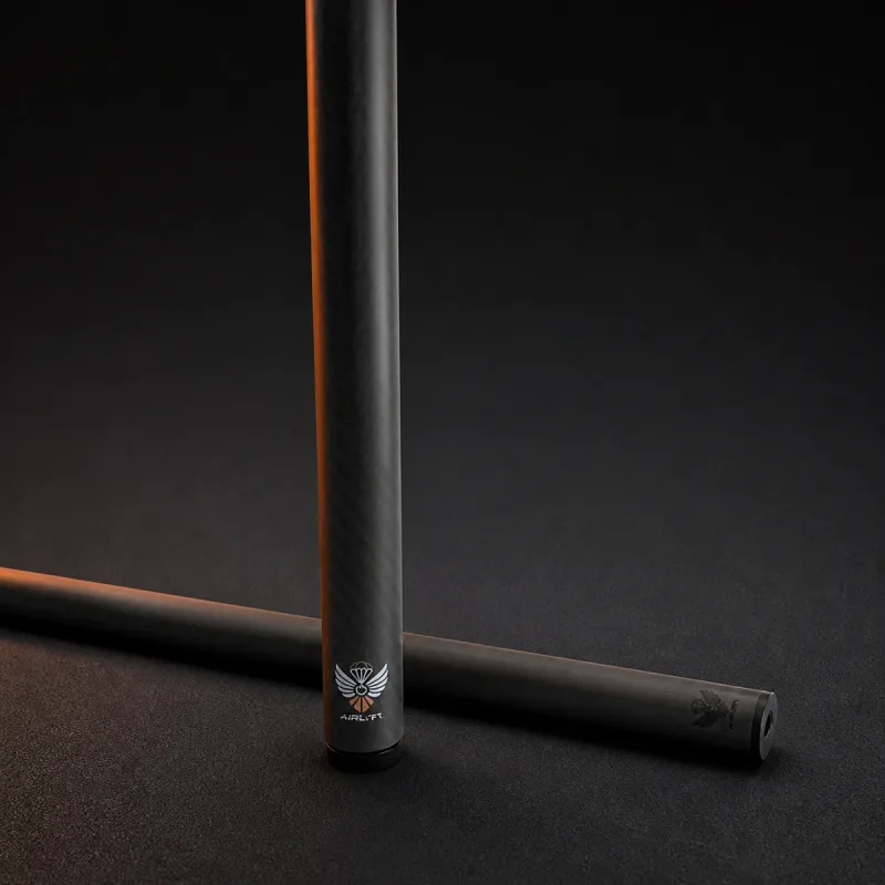 AirLyft carbon fiber cue with its white and orange winged logo, lit by a warm orange edge light